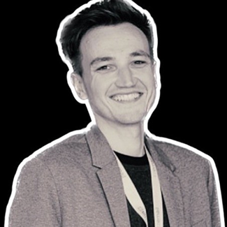 A young man with short hair smiles, wearing a blazer and a lanyard. The image is black and white with a white outline around him, set against a plain black background.